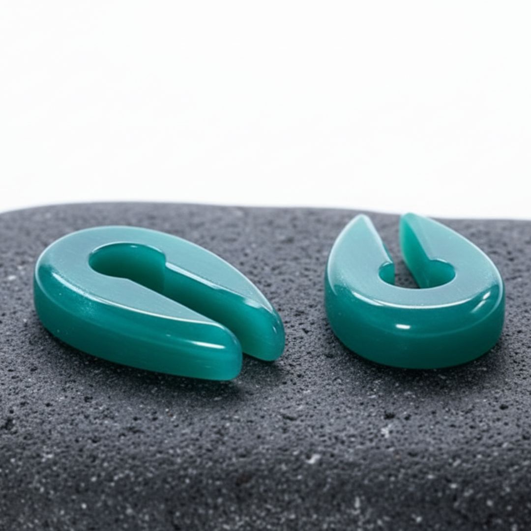 A pair of Aqua Dragon Eye Stone Hangers on rock against a clean white studio background.