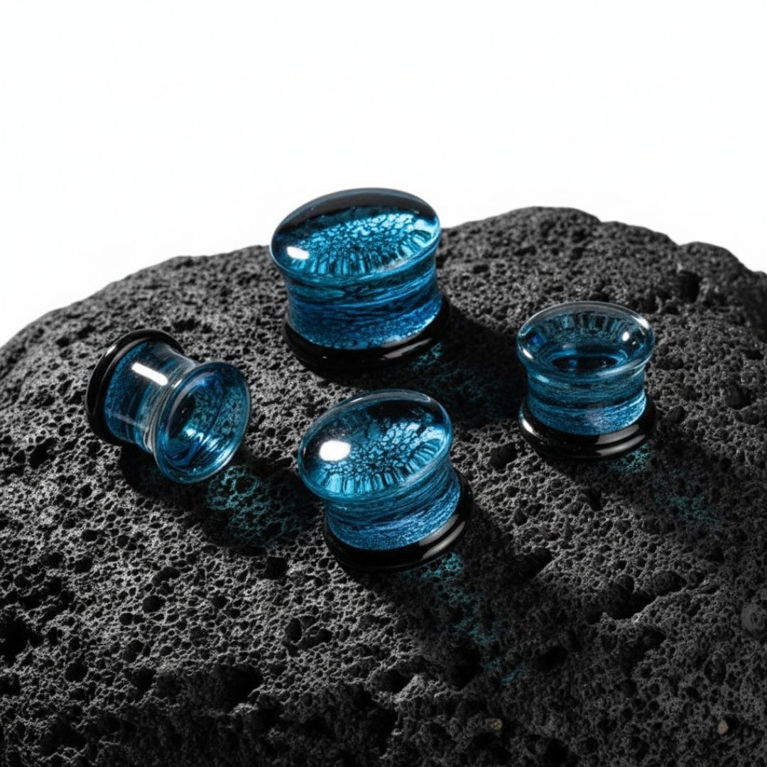 Shattered Glacier Glass Plugs in glass, sizes 6mm-25mm, shot on stone in a white studio.