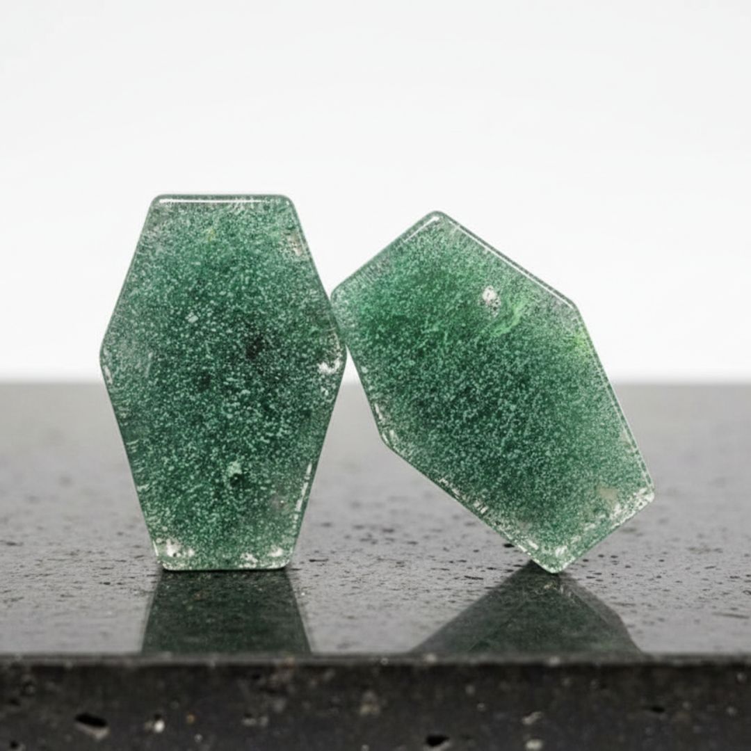 A pair of round Moss Glass Plugs, crafted from smooth green and brown stone glass, displayed against a neutral background.