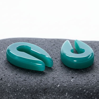 A pair of Aqua Dragon Eye Stone Hangers on rock against a clean white studio background.