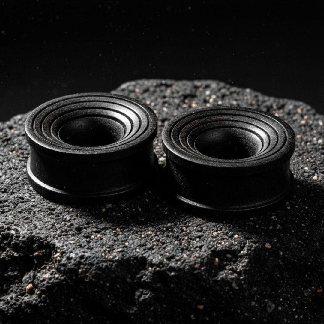 Pair of dark brown Areng wood ripple tunnels shown on a neutral background. Organic wood gauges for stretched ear piercing culture.