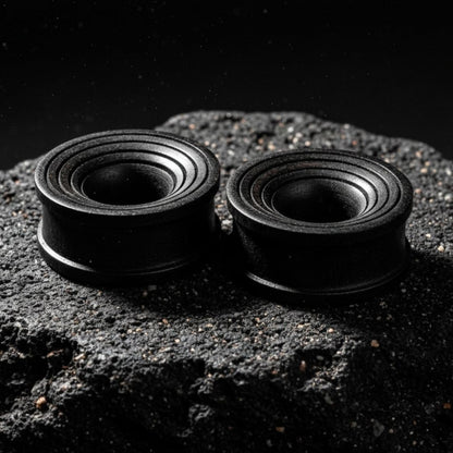 Pair of dark brown Areng wood ripple tunnels shown on a neutral background. Organic wood gauges for stretched ear piercing culture.