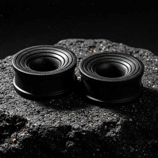 Pair of dark brown Areng wood ripple tunnels shown on a neutral background. Organic wood gauges for stretched ear piercing culture.