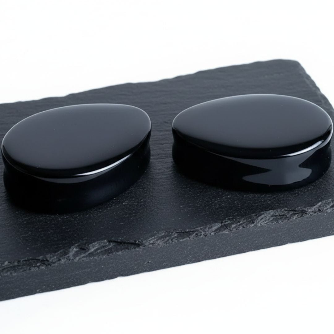Studio photo of Onyx Stone Teardrop Plugs on rock against a clean white background.