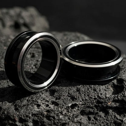Black and silver PVD coated surgical steel tunnels (gauges) for stretched ears. Alt jewelry aesthetic.