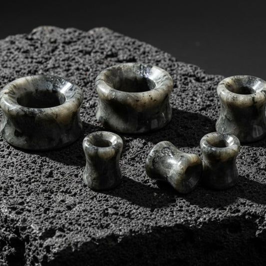 Black Labradorite Stone Tunnels (Larvikite) from 6mm to 30mm on volcanic rock.