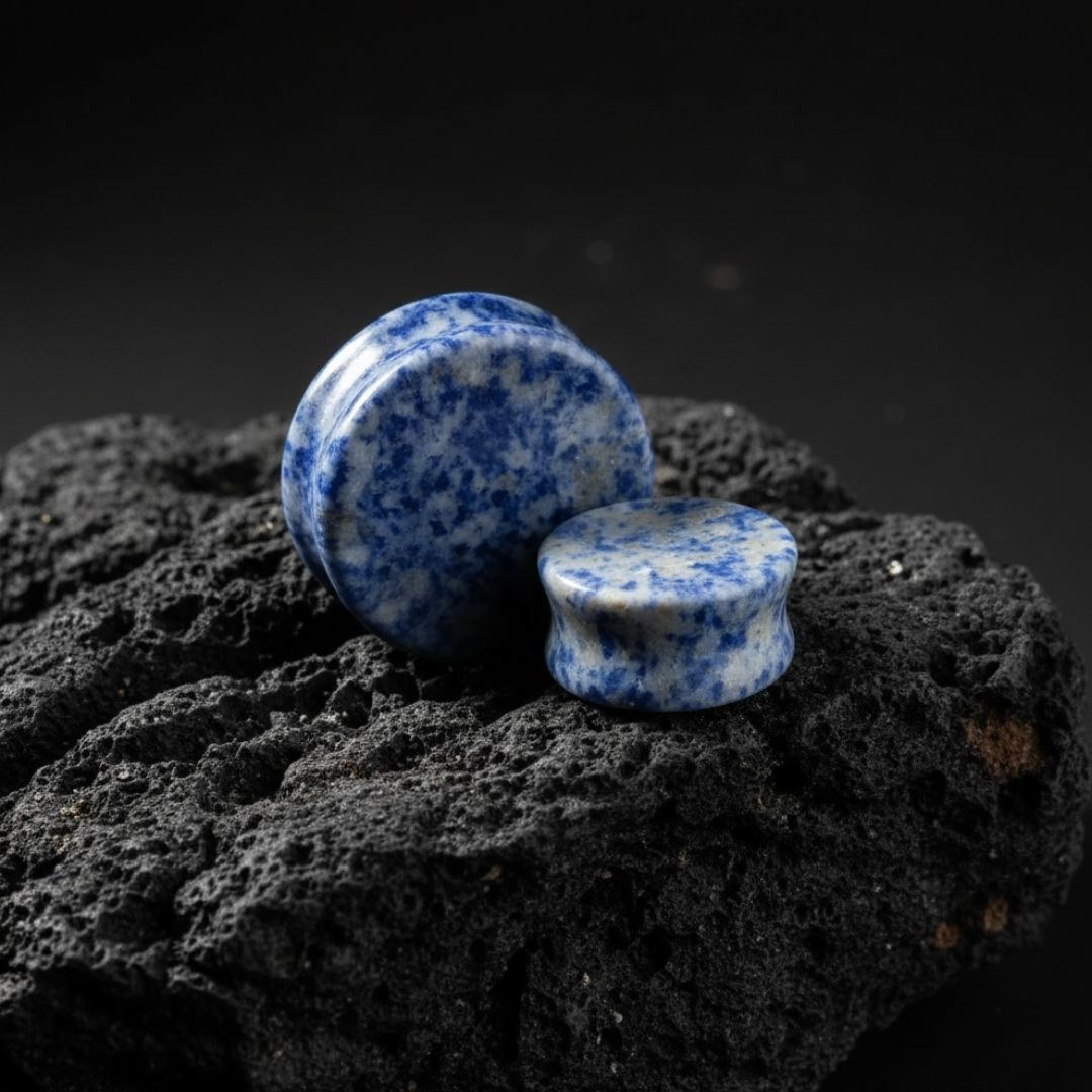 Blue Denim Lapis stone plugs in varying sizes (3mm to 38mm) on a black background. Best gauges for stretched lobes.