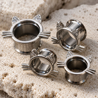 A pair of Kawaii Neko Steel Tunnels (6mm-16mm) sit on stone against a clean white background.