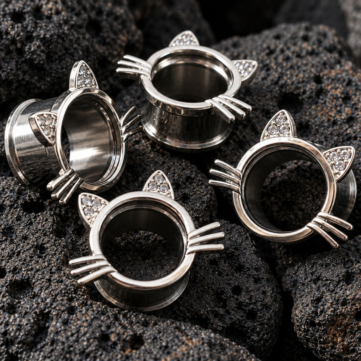 Kawaii Neko Steel Tunnels in 316L steel (6mm-16mm) on dark volcanic rock with sharp lighting.