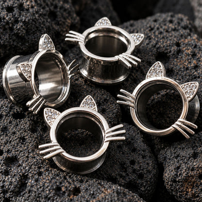 Kawaii Neko Steel Tunnels in 316L steel (6mm-16mm) on dark volcanic rock with sharp lighting.