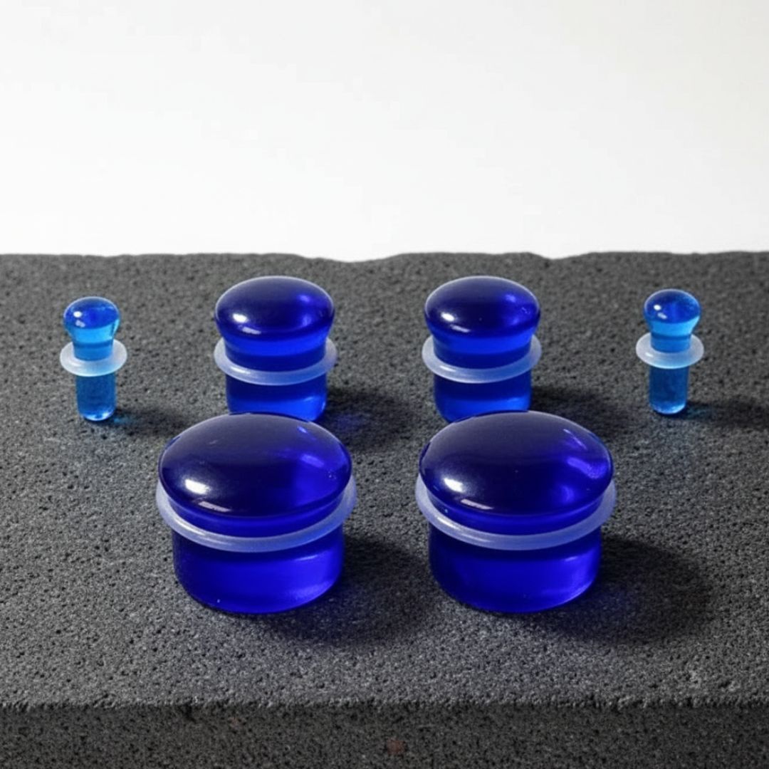 A pair of Deep Cobalt Glass Plugs in various sizes against a clean white studio background.