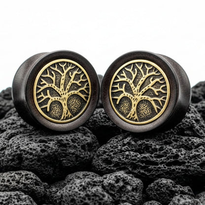 Pair of deep black Ebony Wood plugs with a carved Tree of Life design displayed on a grunge background. Stretched ear gauges.