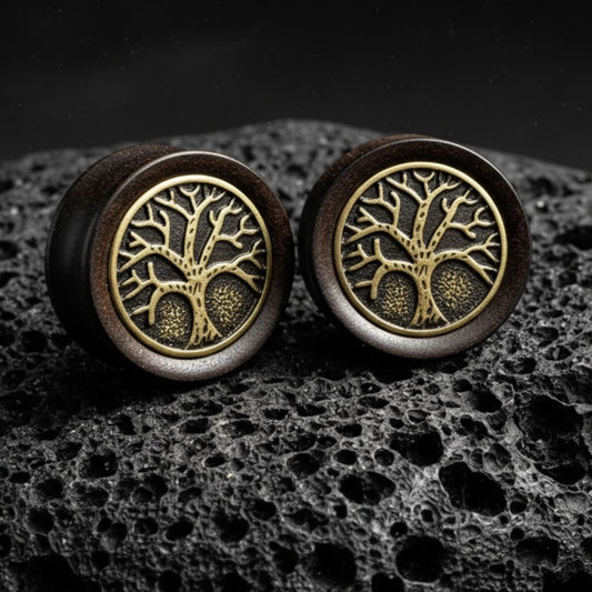 Pair of deep black Ebony Wood plugs with a carved Tree of Life design displayed on a grunge background. Stretched ear gauges.