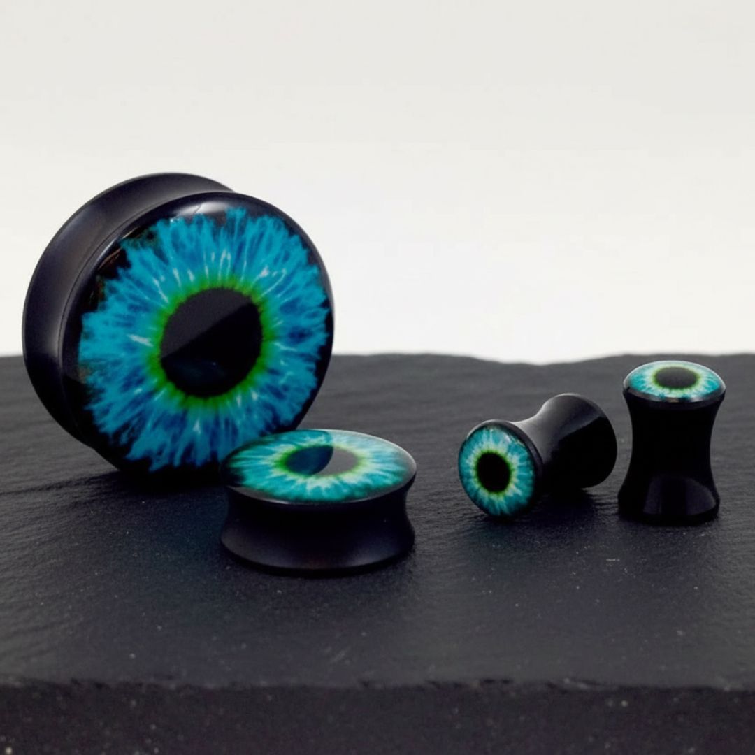 A pair of Frost Wyrm Eye Acrylic Plugs on rock against a clean white studio background.