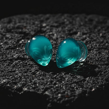 Pair of black and white glass plugs shaped like alien heads for stretched ears and body piercing jewelry.