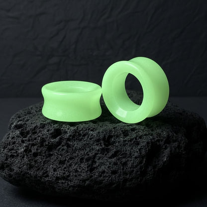 Pair of Glow In The Dark Moonstone Tunnels (gauges) on a dark background. Stretched ear jewelry sizes 6mm to 25mm.