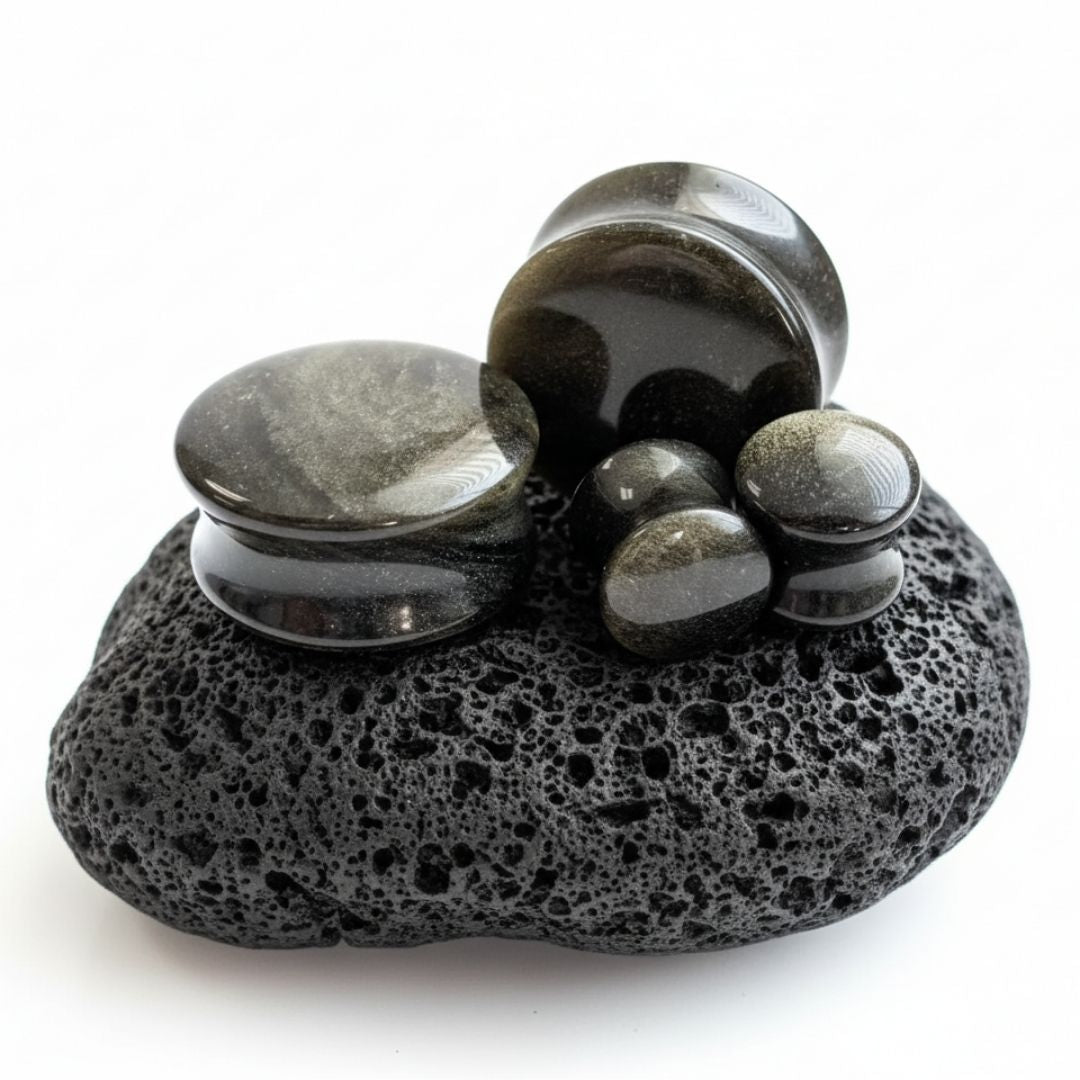 Pair of Golden Obsidian stone plugs (6mm to 25mm) showing the natural gold flash on the black stretched ear gauges.
