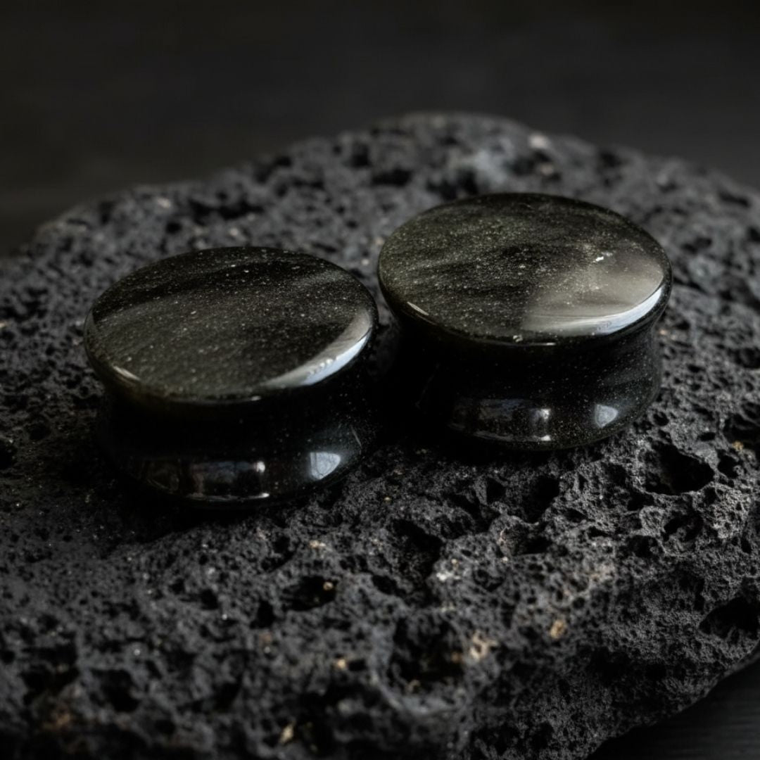 Pair of Golden Obsidian stone plugs (6mm to 25mm) showing the natural gold flash on the black stretched ear gauges.