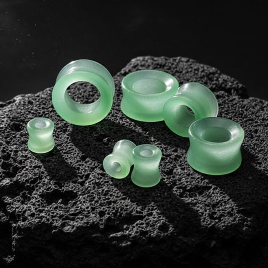 Close-up shot of a pair of polished Green Dragon Eye Stone Tunnels, showing the swirling green, natural stone patterns.