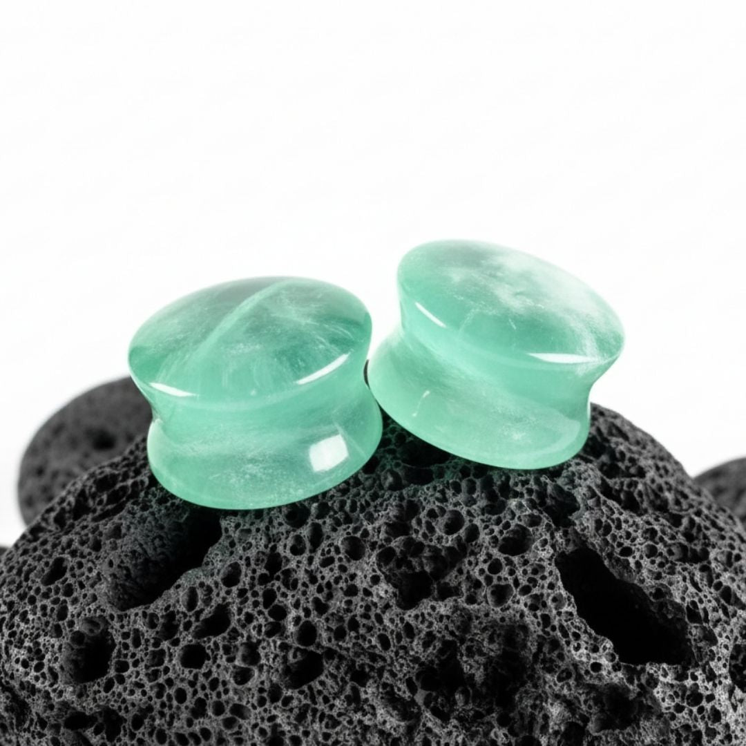A pair of double flare Green Fluorite stone plugs, showing natural banding. Gauges for stretched lobes, sizes 6G to 1 inch.