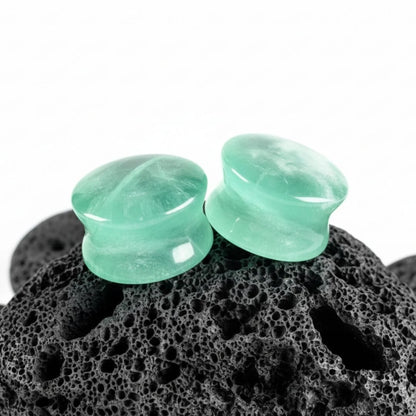 A pair of double flare Green Fluorite stone plugs, showing natural banding. Gauges for stretched lobes, sizes 6G to 1 inch.
