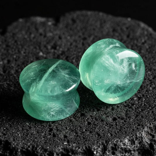 A pair of double flare Green Fluorite stone plugs, showing natural banding. Gauges for stretched lobes, sizes 6G to 1 inch.