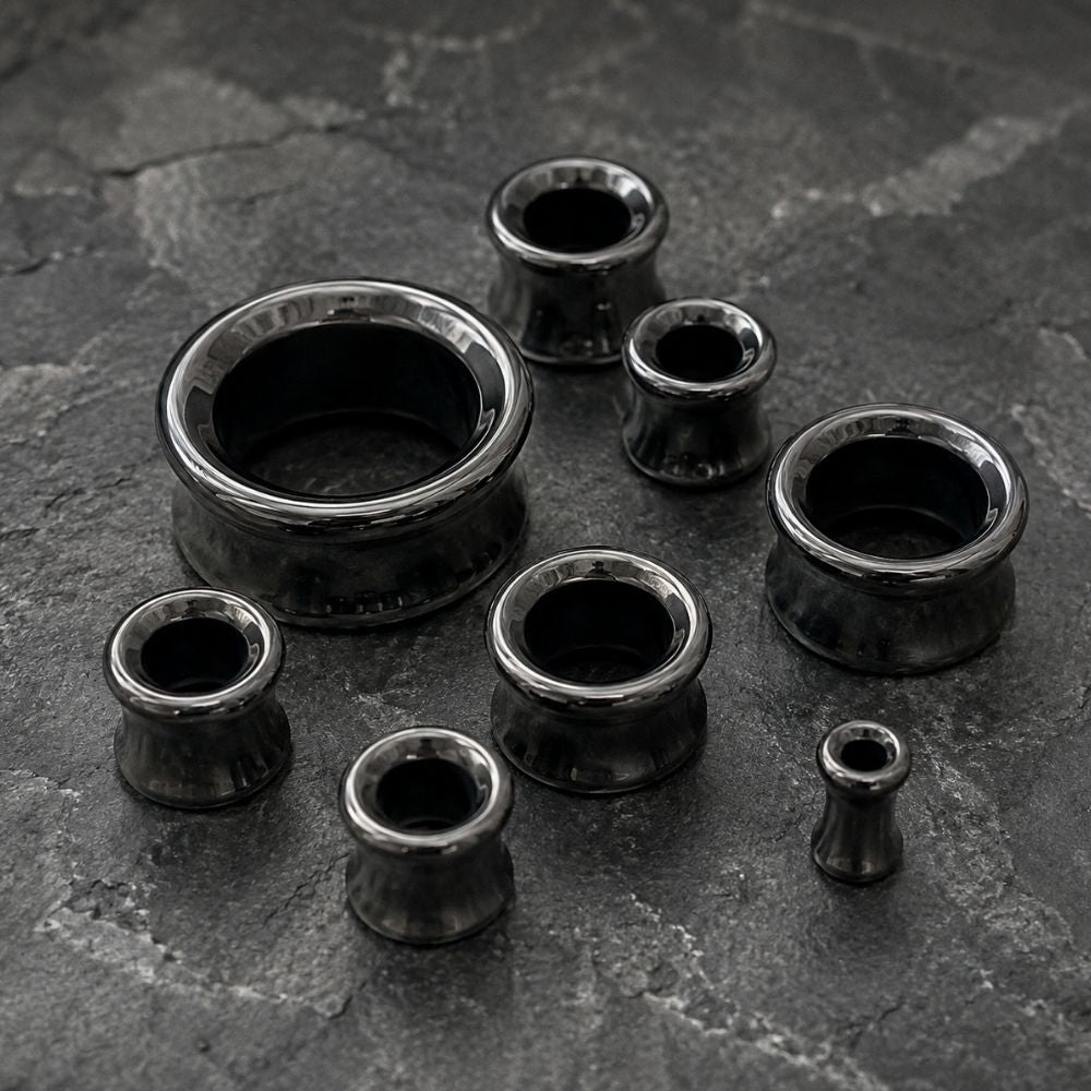 7 Hematite Stone tunnels for stretched ears on a grey stone background