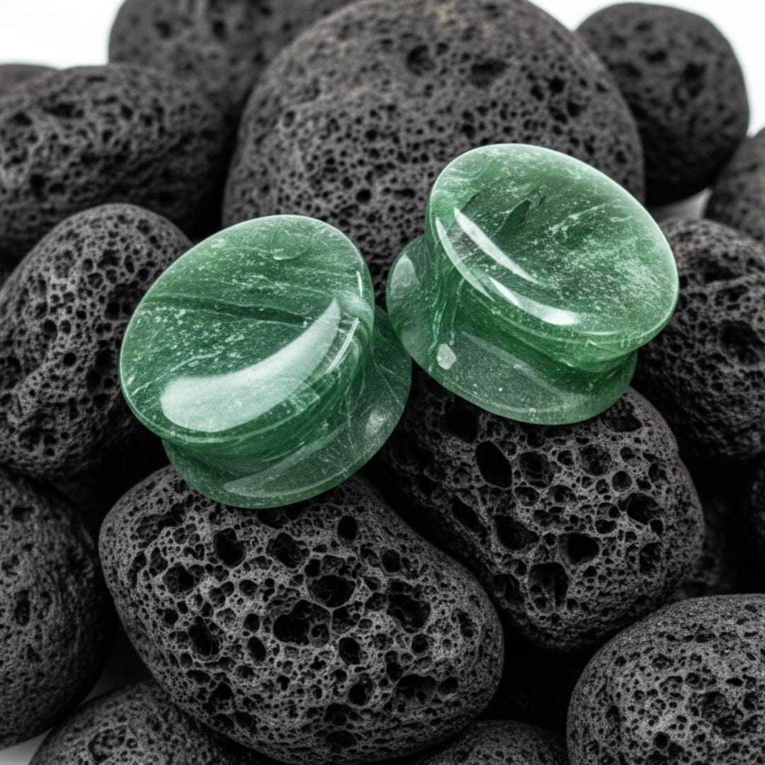 Pair of flared Moss Glass plugs, green and brown natural appearance, shown for stretched ear lobes.