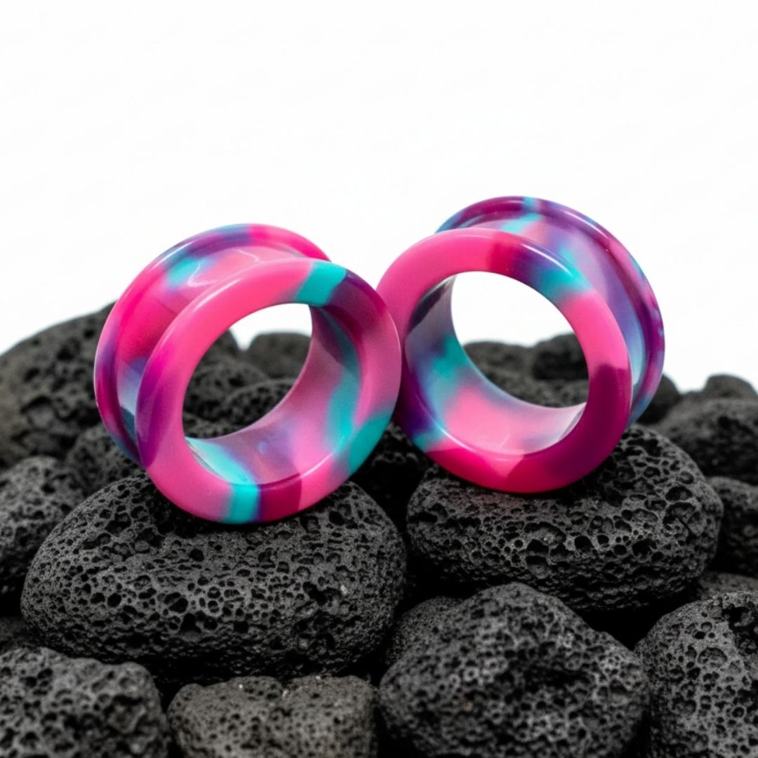 Pair of psychedelic swirl pattern silicone tunnels and flexible ear gauges, available in large sizes for stretched lobes.
