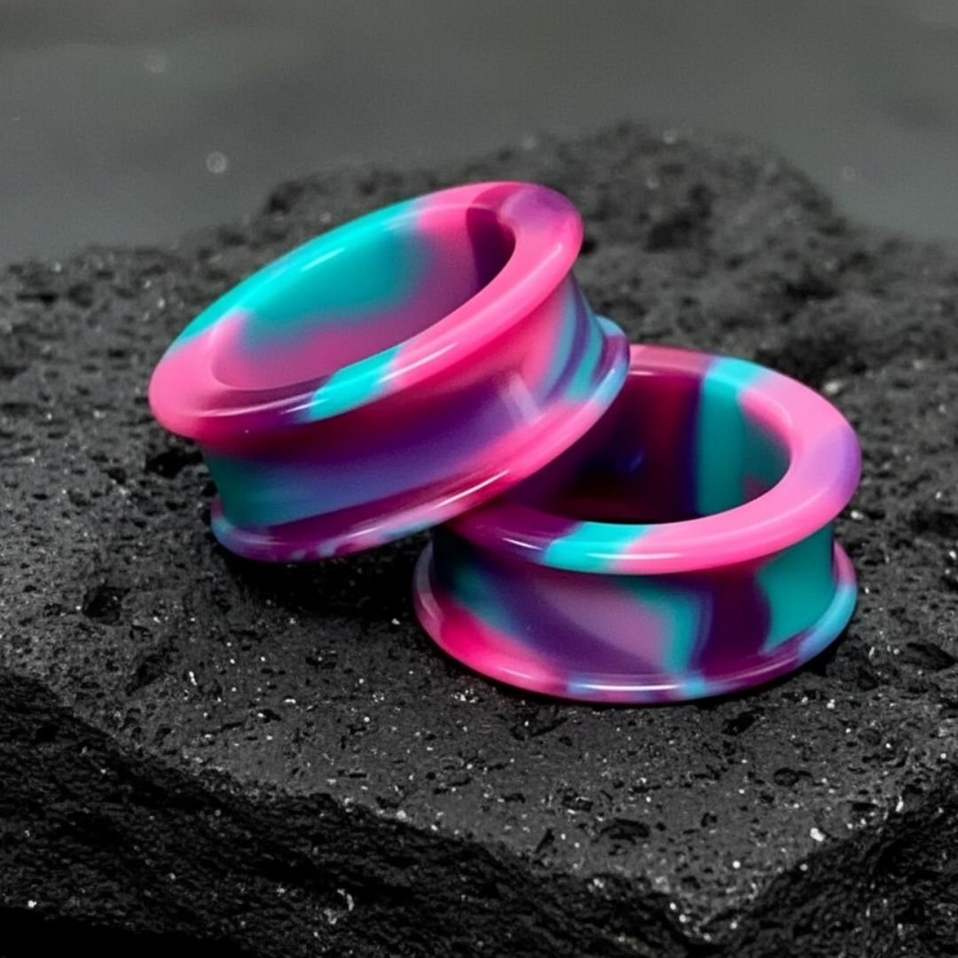 Pair of psychedelic swirl pattern silicone tunnels and flexible ear gauges, available in large sizes for stretched lobes.