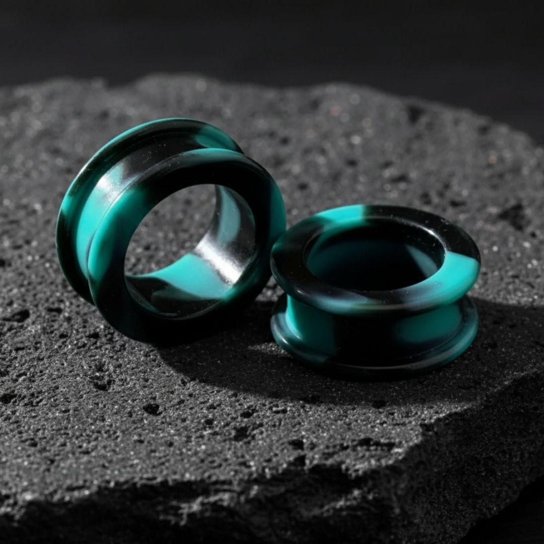 Pair of black retro silicone tunnels for stretched ears, gauges 2G to 2 inches, shown against a dark, alternative background.