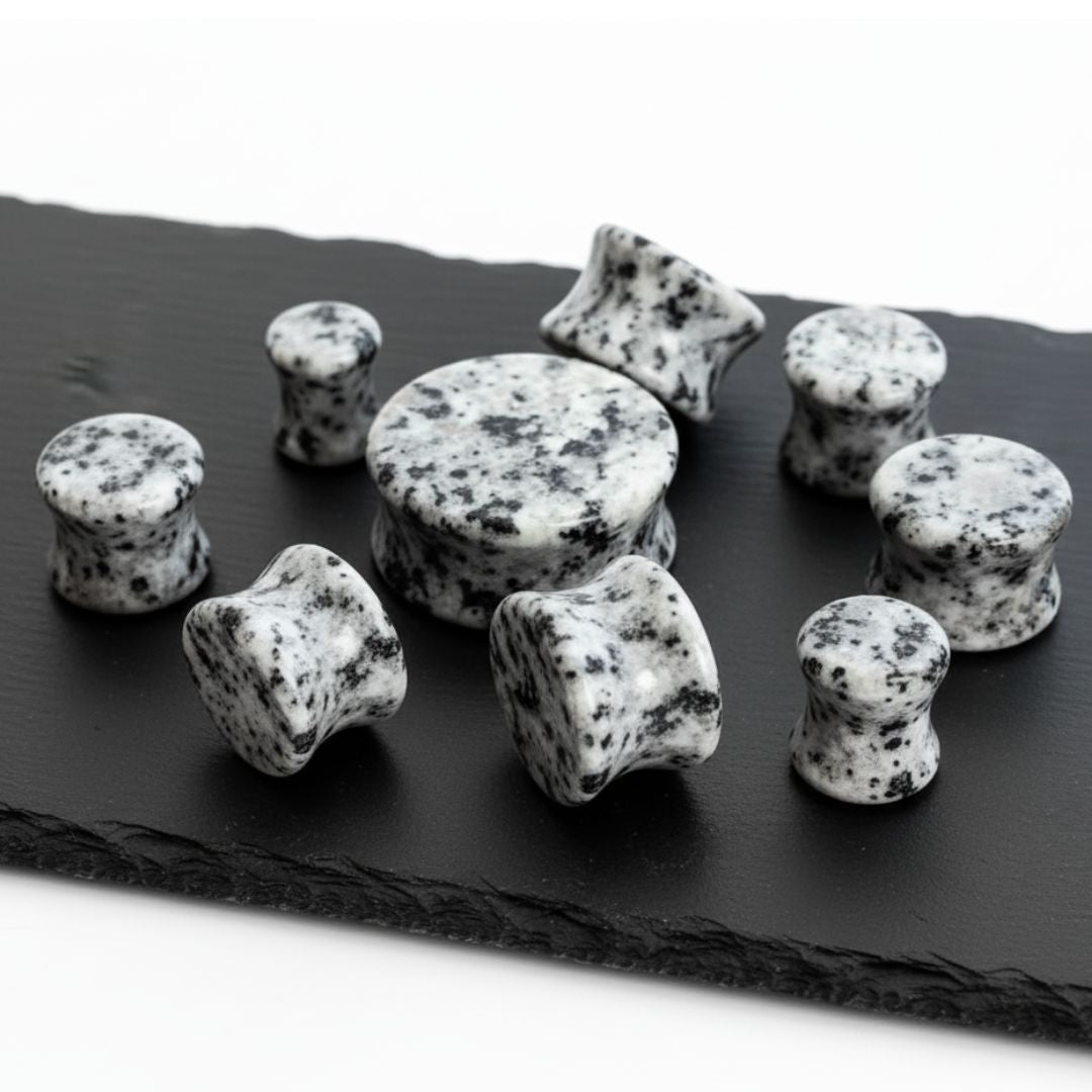 Decorative stones with black and white pattern on a dark slate surface