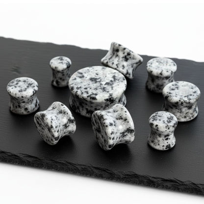 Decorative stones with black and white pattern on a dark slate surface