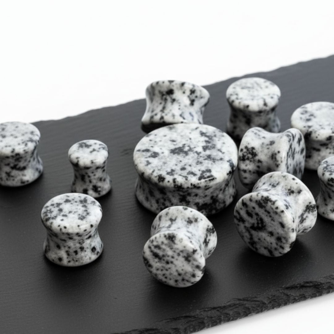 Speckled black and white stones on a dark surface