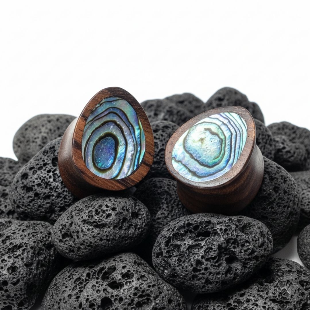 Pair of dark Sono wood teardrop gauges with natural iridescent abalone shell inlay, viewed head-on.