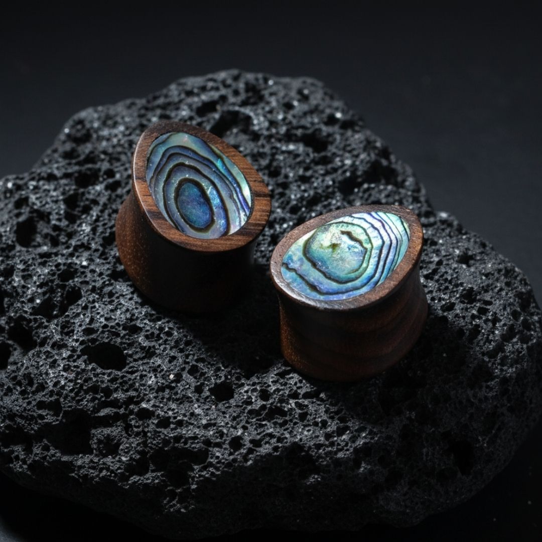 Pair of dark Sono wood teardrop gauges with natural iridescent abalone shell inlay, viewed head-on.