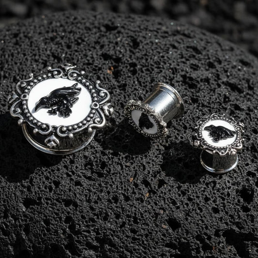 Steel raven plugs on a dark volcanic stone