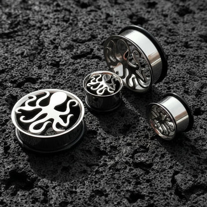 Steel Kraken Tunnels in 316L steel (6mm-30mm) on dark volcanic rock with side lighting.
