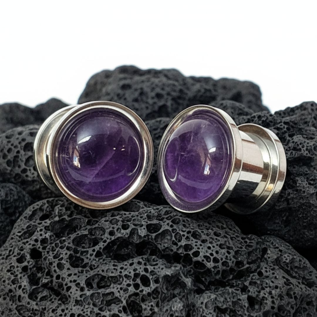 Steel Plugs Amethyst Inlay Gauges on Dark Volcanic Stone