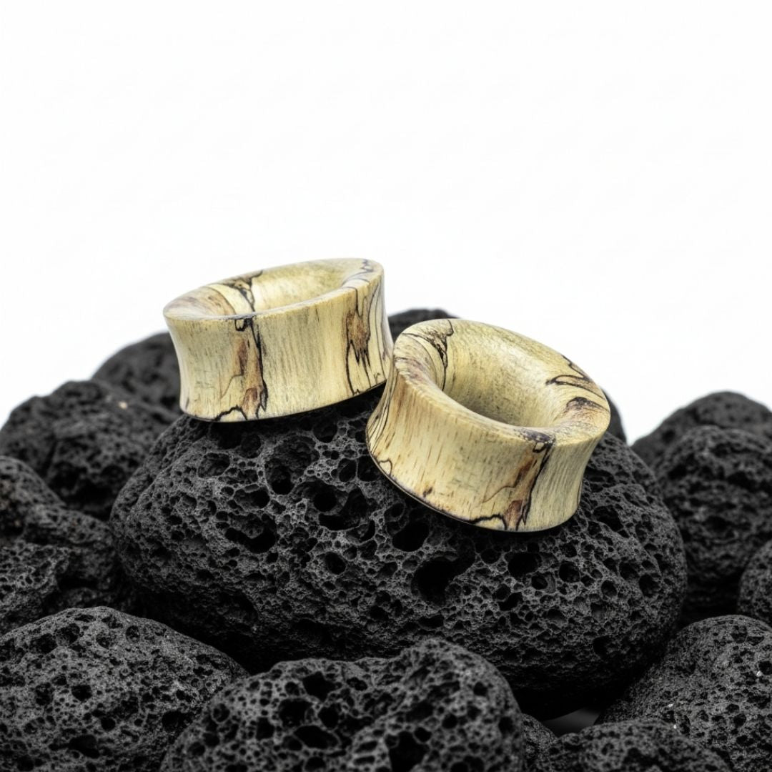 Close-up of dark brown Tamarind Wood Tunnels, displayed in varying sizes (2G to 1 inch) ideal for stretched ears.