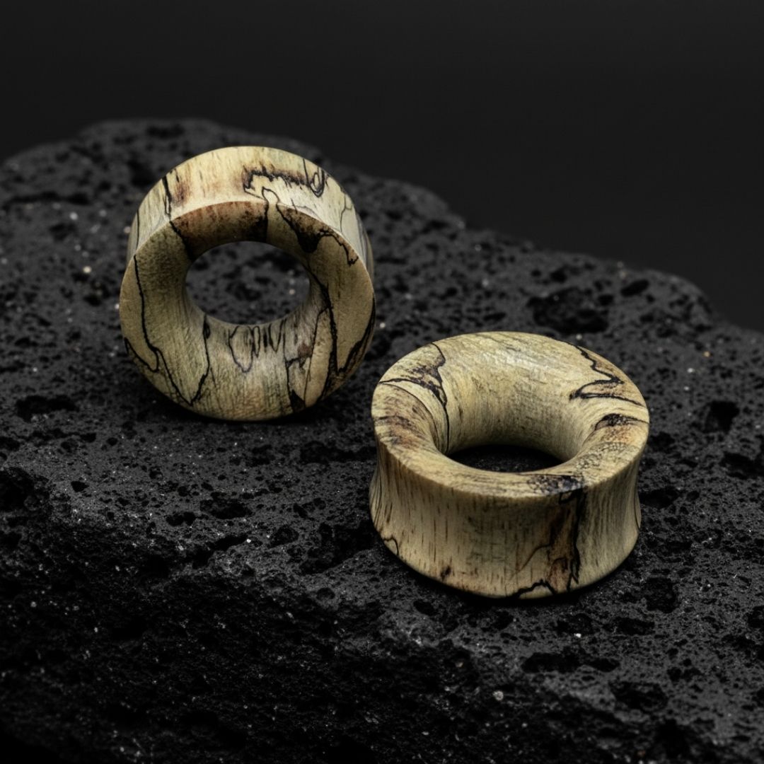 Close-up of dark brown Tamarind Wood Tunnels, displayed in varying sizes (2G to 1 inch) ideal for stretched ears.