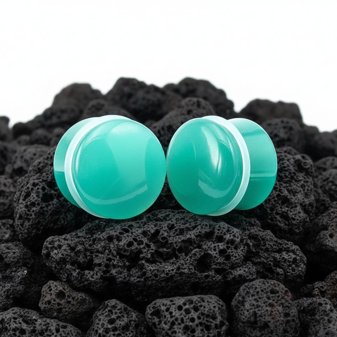 A pair of teal dragon eye stone plugs made of cat eye material for stretched ears, shown in dual-flared style.