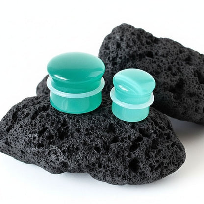 A pair of teal dragon eye stone plugs made of cat eye material for stretched ears, shown in dual-flared style.