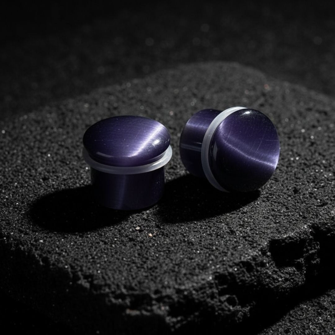 Pair of deep purple violet cat eye stone plugs with a reflective line, double flared gauges, sizes 2G to 16mm.