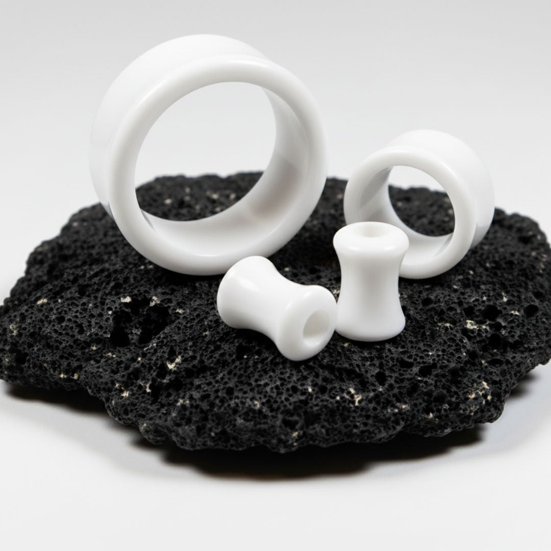 White Acrylic Tunnels for stretched ears on black stone