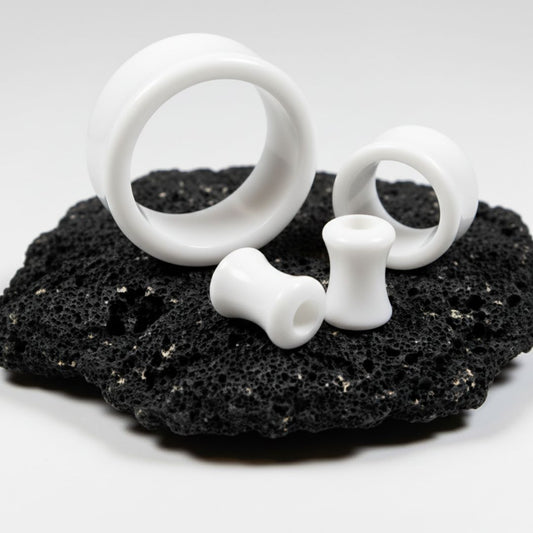 White Acrylic Tunnels for stretched ears on black stone