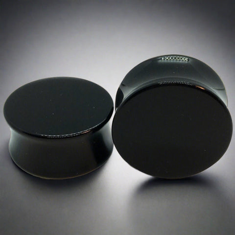 A pair of black acrylic plugs for stretched ears