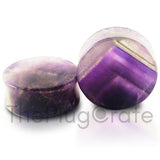 A pair of organic purple amethyst stone plugs for stretched ears; 