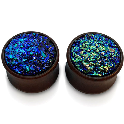 A pair of wood plugs for stretched ears with a faux druzy inlay